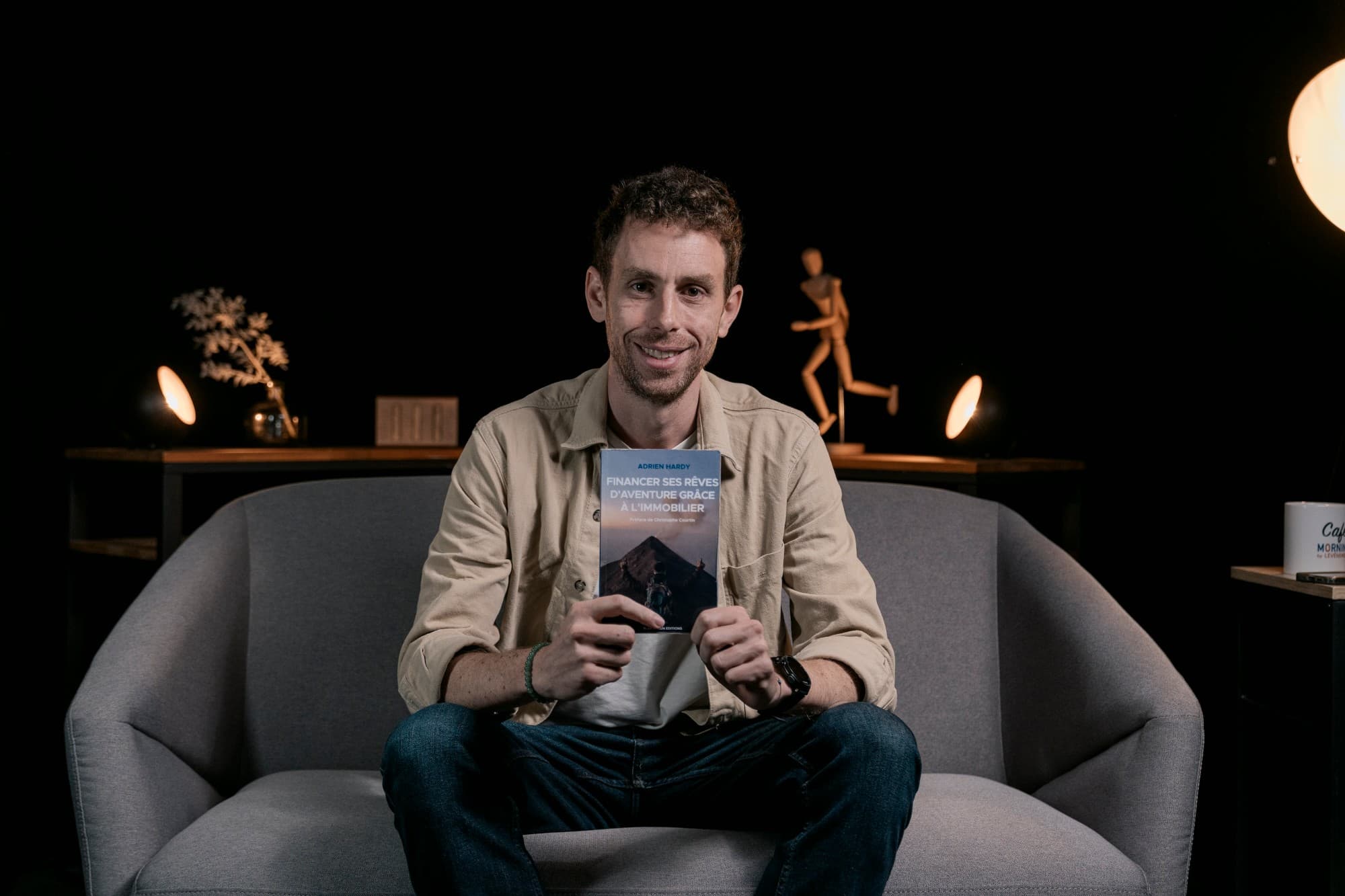 Adrien Hardy, founder of Blue Green, holding his book on financing adventure through real estate
